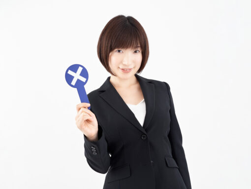 A Japanese female office worker with an x sign on a white background