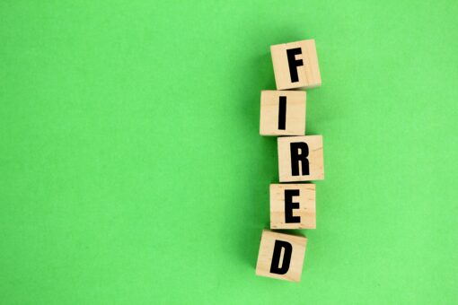 wooden cube with the word fired.