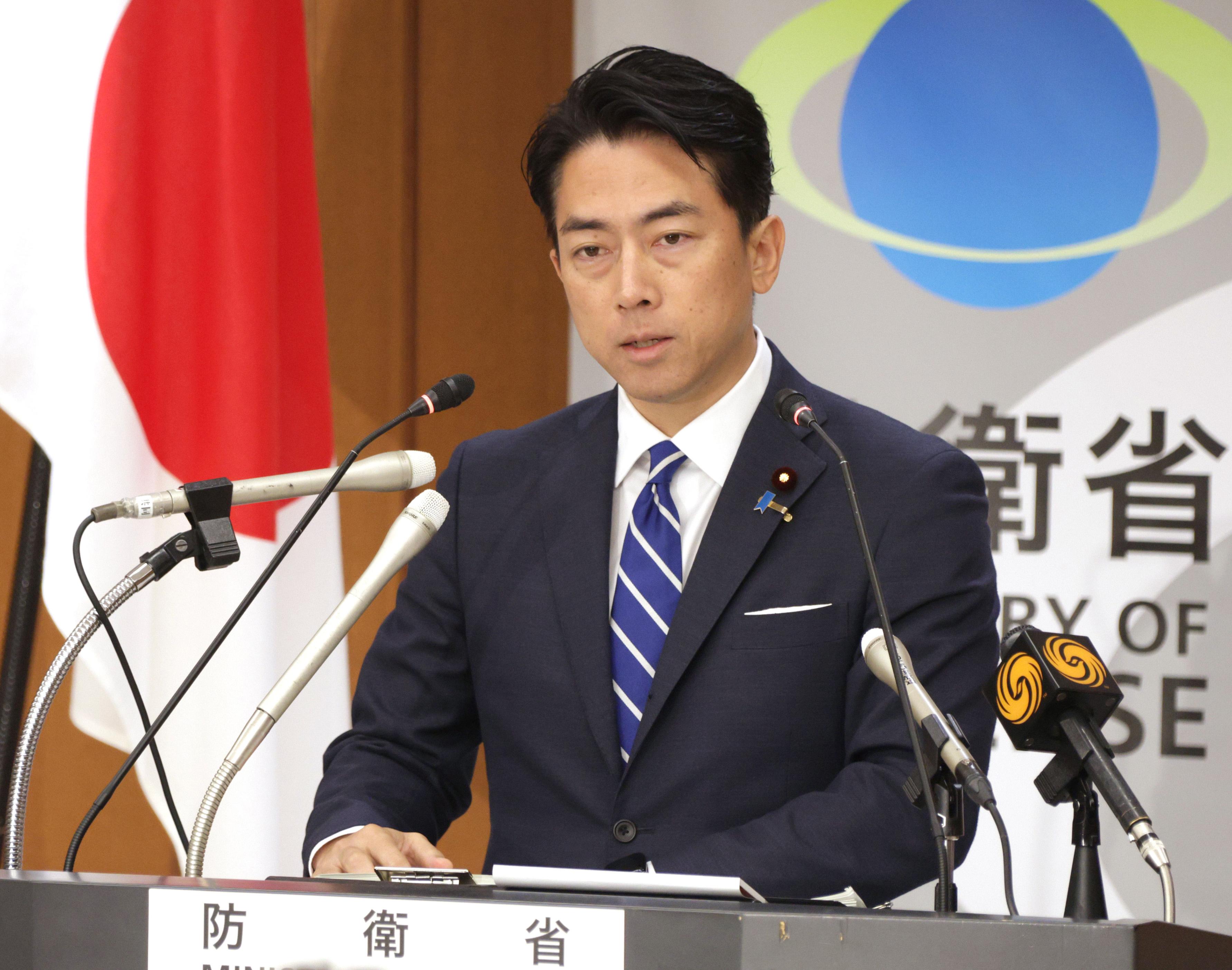 小泉防衛大臣の記者会見風景。国旗を背に、厳しい安全保障環境を語る姿が印象的です。(出典: 47NEWS, CC BY-SA 4.0)